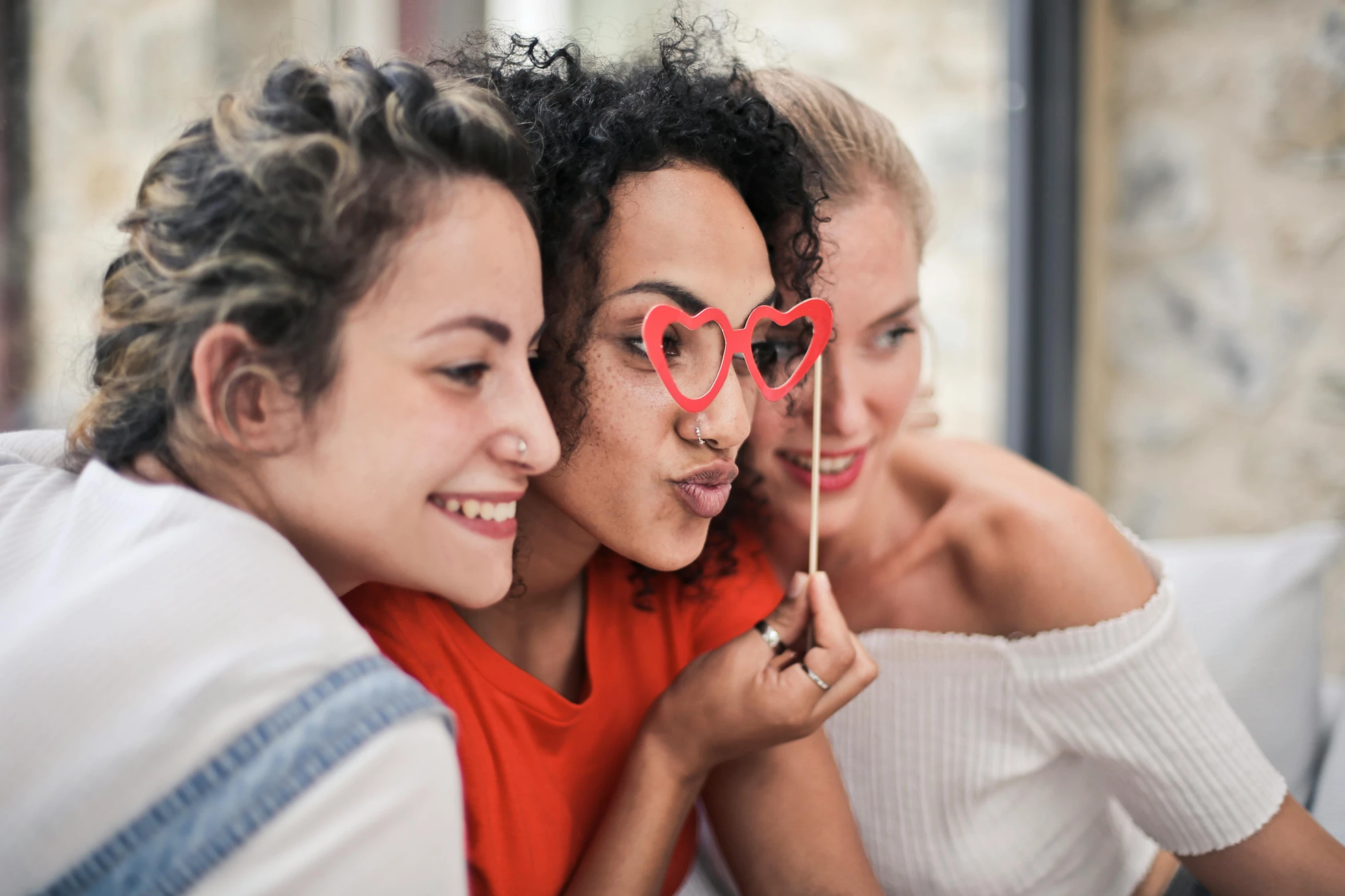 a group of women sitting next to each other on a couch, a picture, trending on pexels, heart shaped face, photo booth, on a white table, profile image