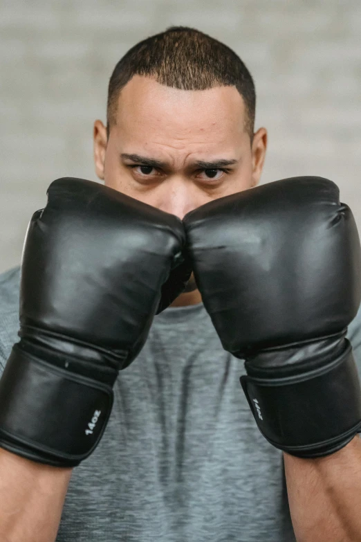 a man with boxing gloves covering his face, an album cover, pexels contest winner, fighting stance energy, avatar image, heavily upvoted, headshot profile picture