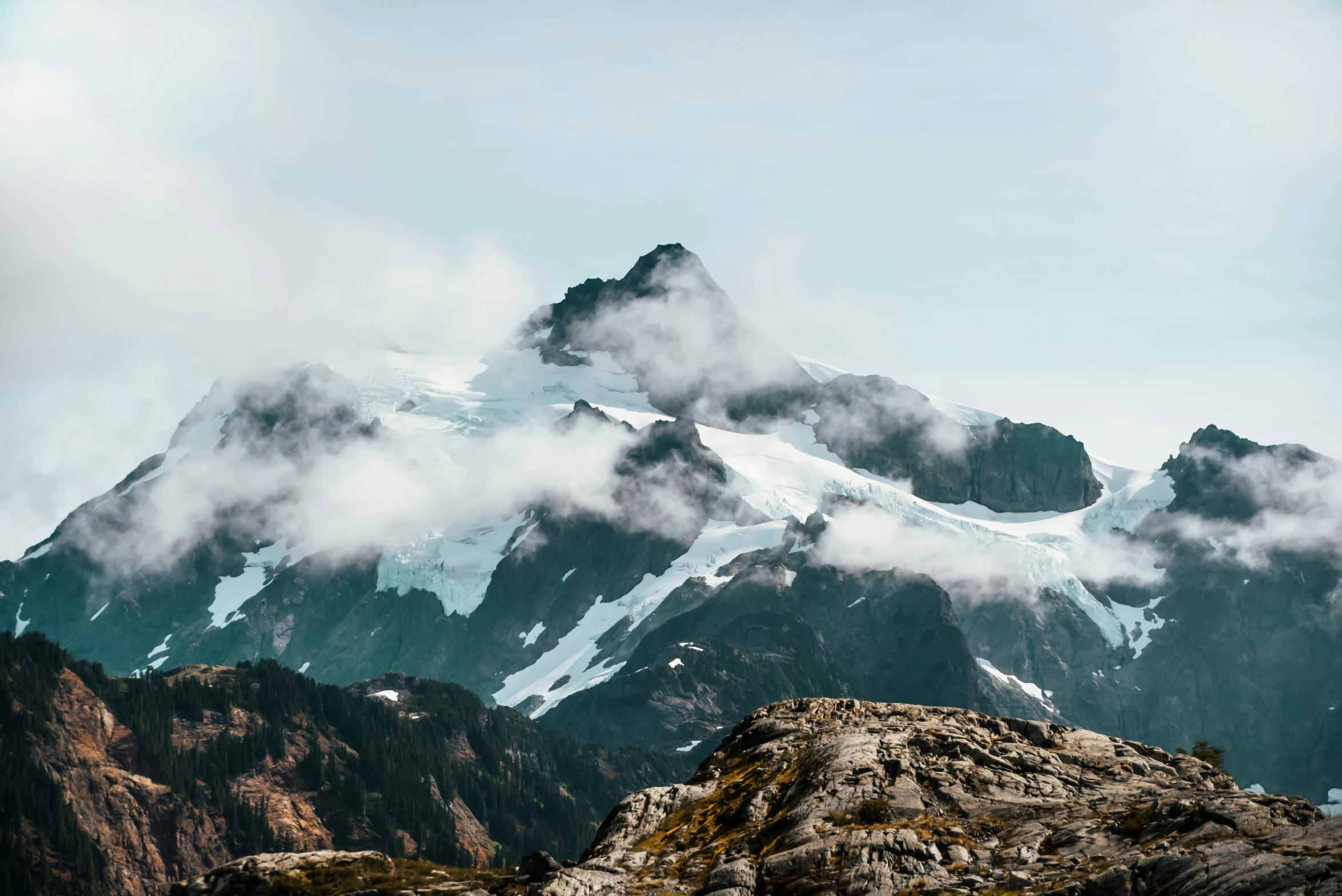 a large mountain covered in snow and clouds, an album cover, pexels contest winner, pacific northwest coast, unsplash 4k, craggy, mountains of ice cream