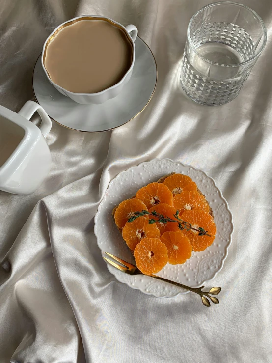 a white plate topped with orange slices next to a cup of coffee, by Henriette Grindat, thumbnail, seasonal, uncropped, 🎀 🧟 🍓 🧚