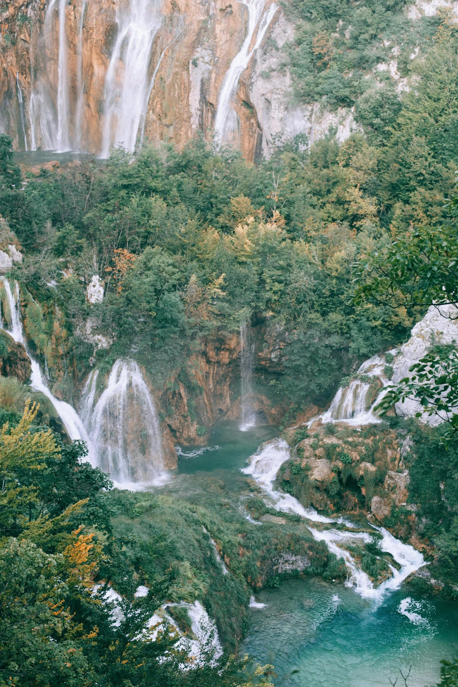 a waterfall in the middle of a lush green forest, inspired by Jan Kupecký, white travertine terraces, cliffs, lakes, fall