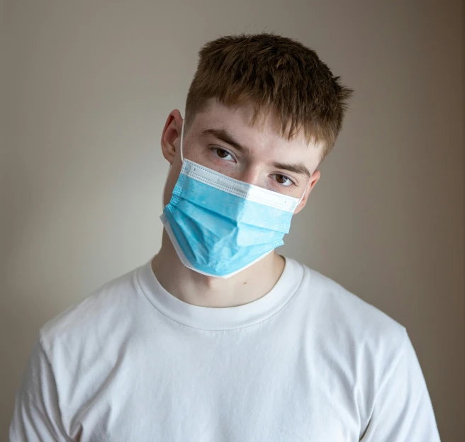 a close up of a person wearing a face mask, trending on pexels, young man with short, surgical supplies, with pale skin, portrait of a handsome