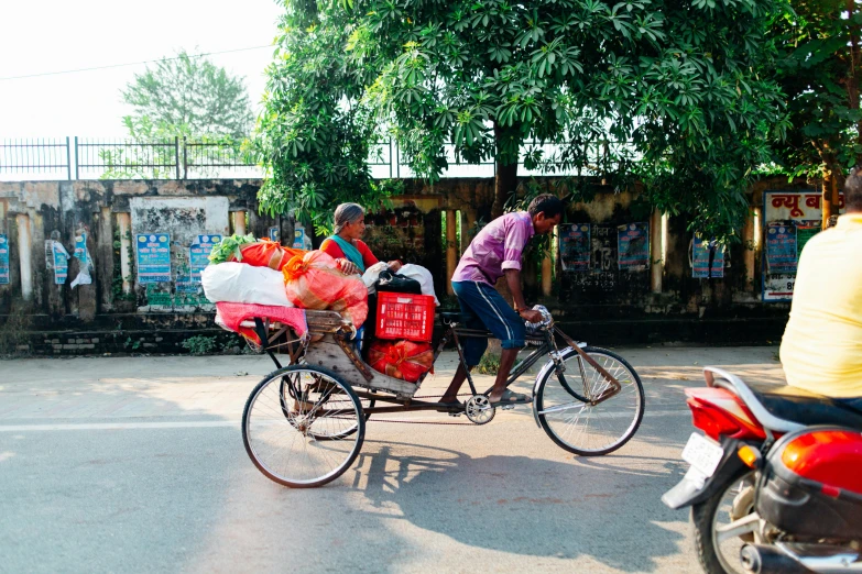 a man riding a bike with a basket on the back of it, by Carey Morris, pexels contest winner, bengal school of art, people shopping, foil, instagram picture, thumbnail