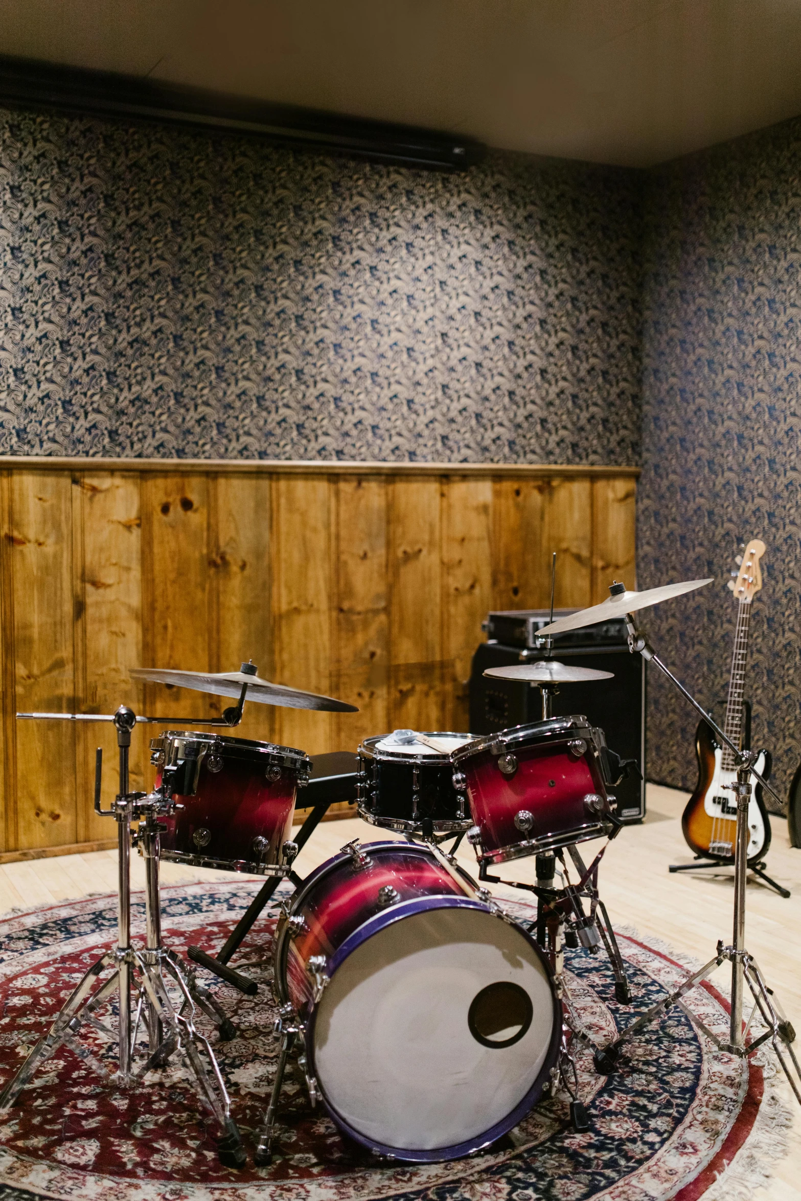 a drum kit sitting on top of a rug in a room, studio bind, panoramic, back rooms, promo image