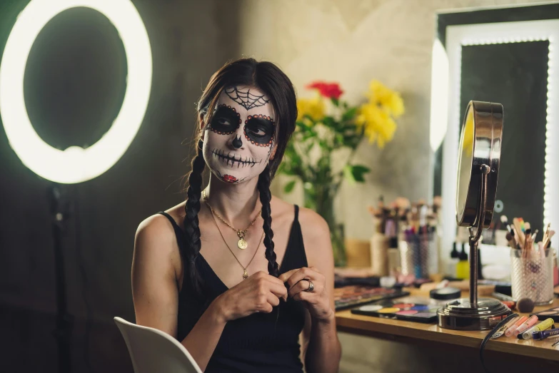 a woman that is sitting in front of a mirror, pexels contest winner, lowbrow, skull face paint, woman with braided brown hair, wearing a fancy dress, avatar image