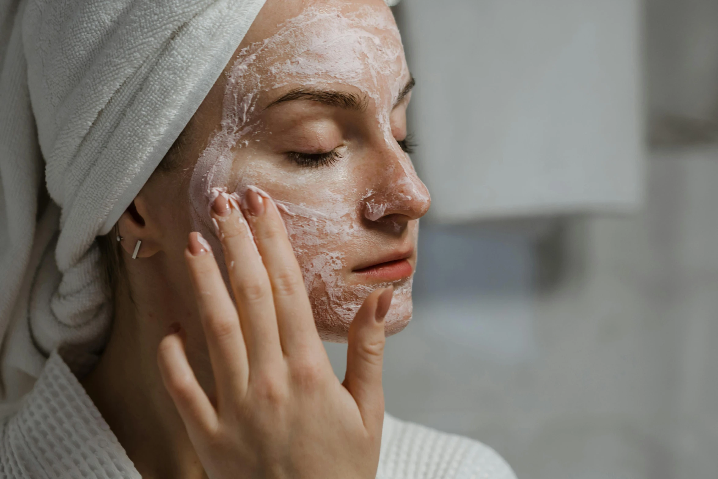 a close up of a person with a towel on their head, hands on face, freckled pale skin, putting makeup on, ad image