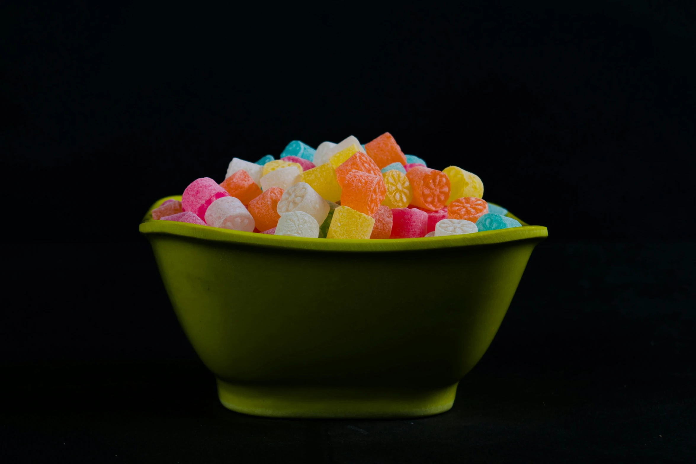 a bowl of gummy bears on a black background, by Adam Marczyński, square, 2 4 mm iso 8 0 0, pastel neon, corn