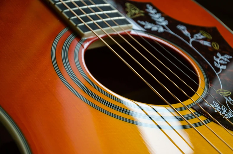 a close up of an orange acoustic guitar, by Joe Bowler, no duplicate image