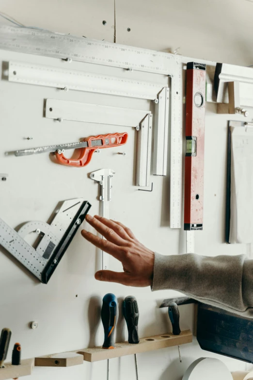 a man that is standing in front of a wall, arbeitsrat für kunst, tools for science research, knolling, garage, promo image