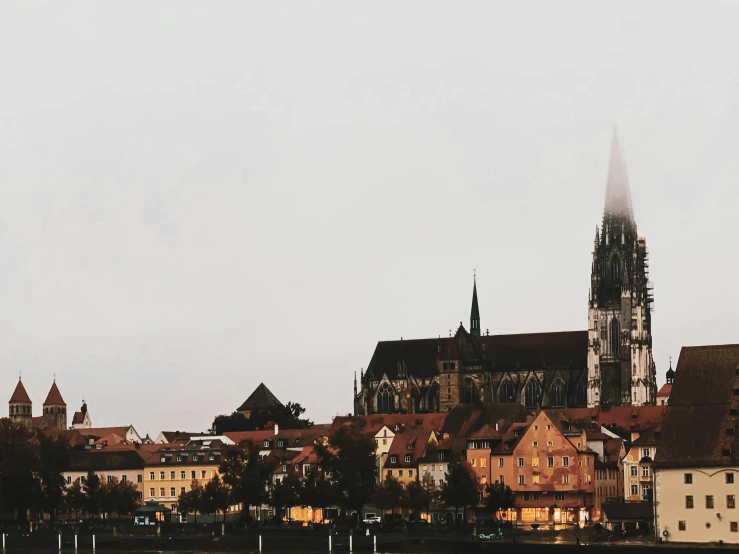 a large body of water with a city in the background, by Daniel Lieske, pexels contest winner, renaissance, gothic church background, header text”, beautiful small town, brown