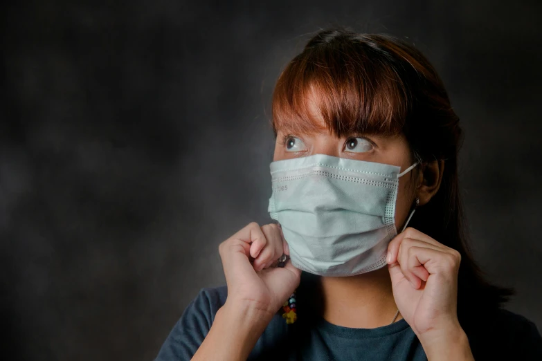 a woman with a face mask covering her mouth, pexels contest winner, nurse, haze over the shoulder shot, grey, thumbnail