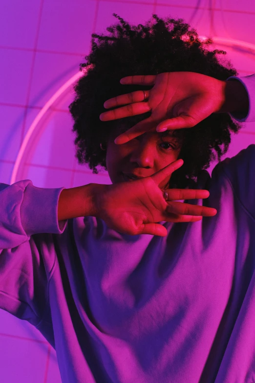 a woman covering her eyes with her hands, an album cover, trending on pexels, afrofuturism, young man in a purple hoodie, ((purple)), bisexual lighting, doing a sassy pose