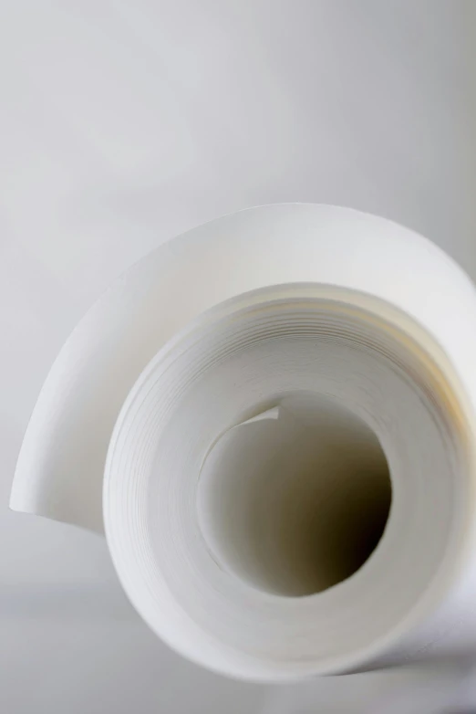 a roll of white paper sitting on top of a table, plasticien, enhanced quality, up close, soft white glow, waist - up