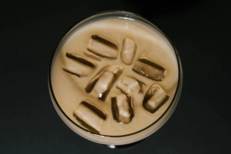 a close up of a drink with ice cubes in it, a portrait, reddit, milk and mocha style, seen from straight above, on a black background, thumbnail