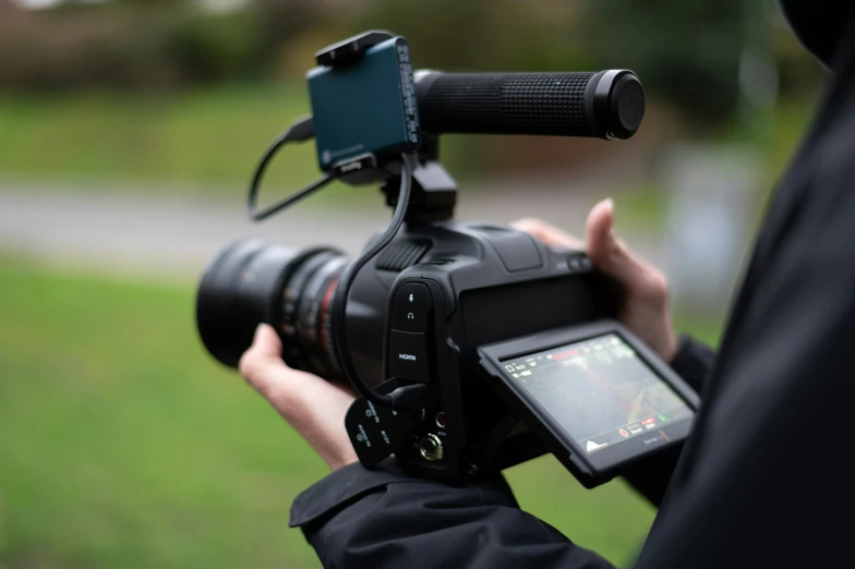 a close up of a person holding a camera, a picture, canon c300, back towards camera, full device, panavision psr r-200