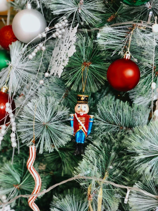 a close up of a christmas tree with ornaments, a portrait, by Julia Pishtar, pexels, soldier outfit, high quality product image”, made of glazed, classical ornament