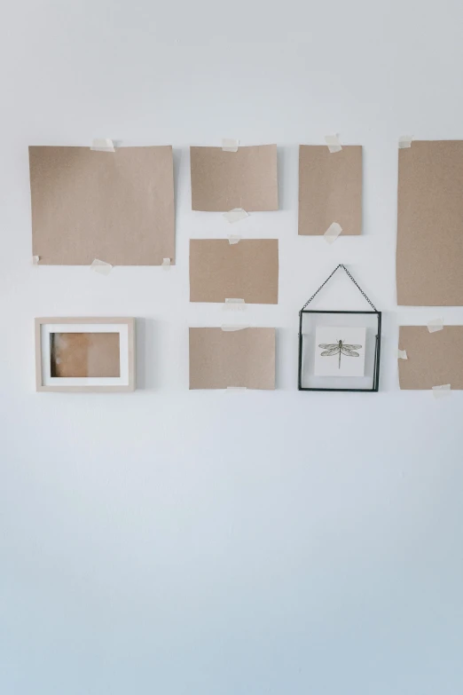 a room with several pieces of cardboard on the wall, a picture, by Matthias Stom, trending on unsplash, square pictureframes, white background wall, sheet paper, high quality photo