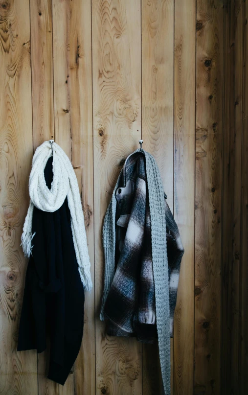 a couple of coats hanging on a wooden wall, by Jessie Algie, unsplash, scarf made from spaghetti, dwell, silver accessories, flannel