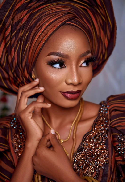 a woman wearing an orange and brown turban, an album cover, inspired by Chinwe Chukwuogo-Roy, trending on pexels, evening makeup, modest, an intricate, 4 k