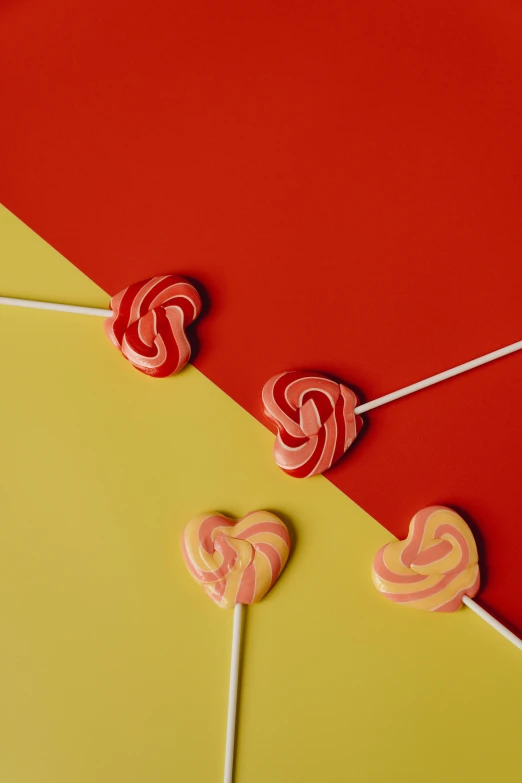 red and yellow lollipop lollipop lollipop lollipop lollipop lollipop lollipop lollipop lo, trending on pexels, pop art, several hearts, swirles, edible, coral red