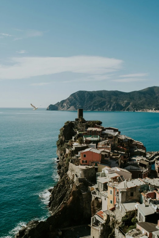 a town sitting on top of a cliff next to the ocean, running through italian town, unsplash photography, slide show, color image