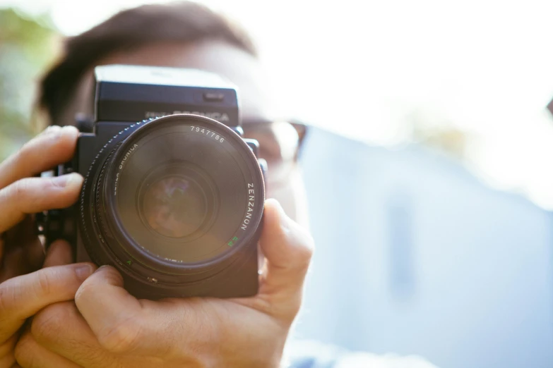 a man taking a picture with a camera, pexels contest winner, lensflare, holding it out to the camera, zoomed in shots, headshot profile picture