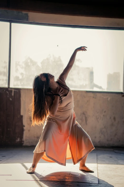 a woman is dancing in front of a window, by Jessie Algie, unsplash, harsh sun light, performance, lachlan bailey, vessels