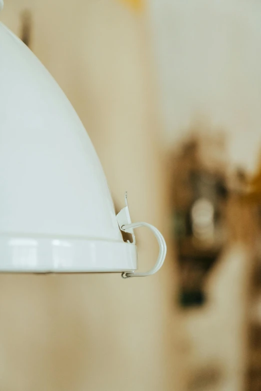 a white light hanging from a ceiling in a room, inspired by George Henry, trending on pexels, close up shot from the side, enamel, detailed product image, close up bust shot