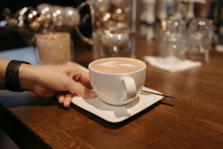 a person sitting at a table with a cup of coffee