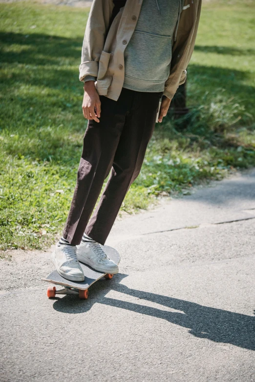 a man riding a skateboard down a sidewalk, a picture, brown pants, curated collections, sport clothing, zoomed out full body