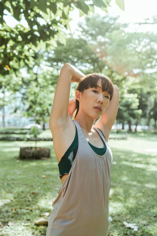 a woman stretching her arms in a park, inspired by Gong Kai, unsplash, realism, wearing : tanktop, 奈良美智, androgynous person, sleeveless