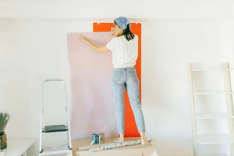 a woman standing on a ladder painting a wall, a minimalist painting, trending on pexels, pink and orange, wall paper, wearing translucent sheet, background image