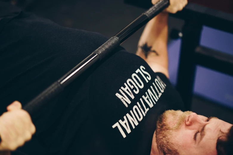 a man that is laying down with a baseball bat, by Steve Prescott, unsplash, private press, carrying two barbells, close up photograph, scott robertson, slightly pixelated