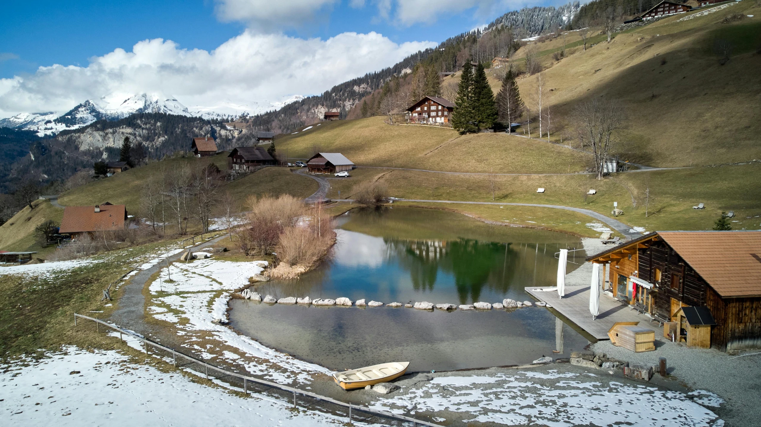 a small pond in the middle of a snow covered field, by Werner Andermatt, pexels contest winner, les nabis, wellness pool, in a park and next to a lake, a green, alp