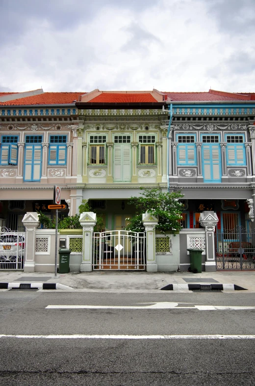 a row of houses sitting on the side of a road, inspired by Ina Wong, art nouveau, singapore, neo classical architecture, nice colour scheme, very very intricate
