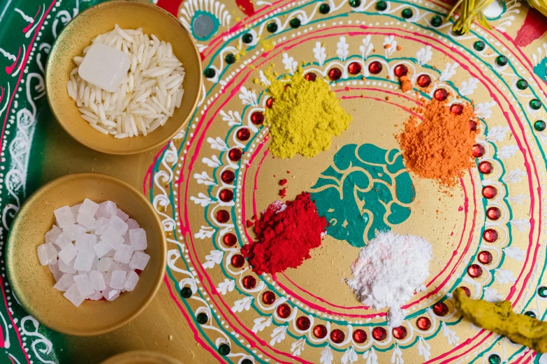 a close up of a plate of food on a table, a detailed painting, by Julia Pishtar, trending on unsplash, process art, hindu ornaments, exploding powder, made out of sweets, scarlet and yellow scheme