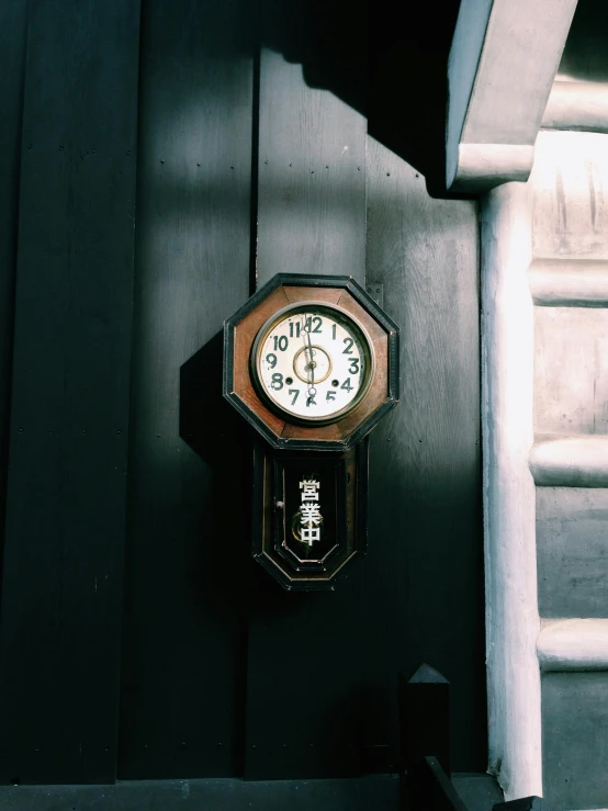 a clock that is on the side of a building, a photo, by Yasushi Sugiyama, unsplash, small room in tokyo, manufactured in the 1920s, 🚿🗝📝, tall door