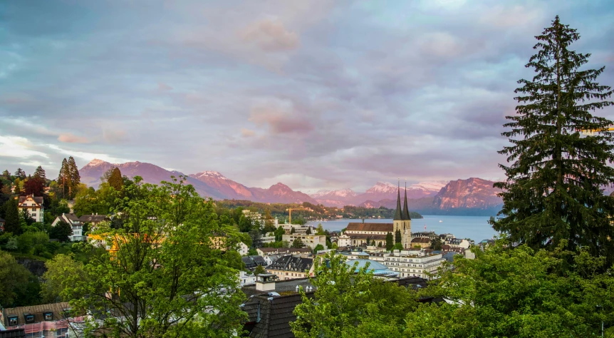 a view of a town with mountains in the background, by Johannes Voss, pexels contest winner, summer evening, 4 k cinematic panoramic view, herzog de meuron, fjords