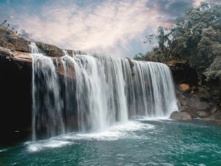 a waterfall in the middle of a body of water, with a waterfalls