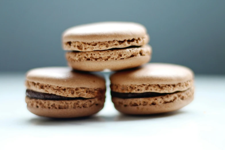 three chocolate macarons stacked on top of each other, a macro photograph, by Alice Mason, unsplash, taken in the late 2010s, 15081959 21121991 01012000 4k, snacks, thumbnail
