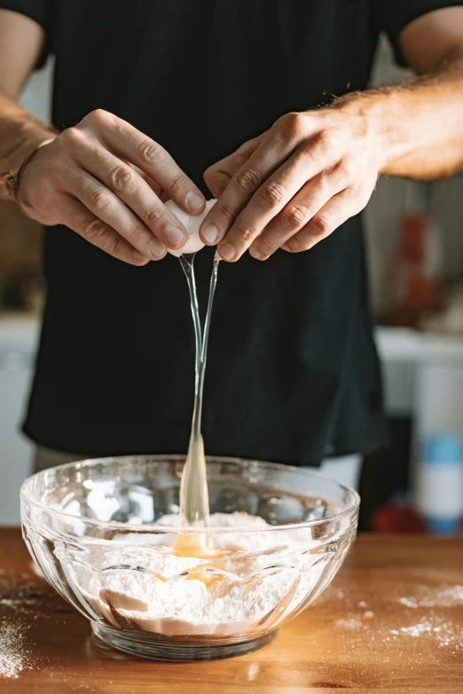 a person mixing ingredients in a bowl on a table, tall, splash image, thumbnail