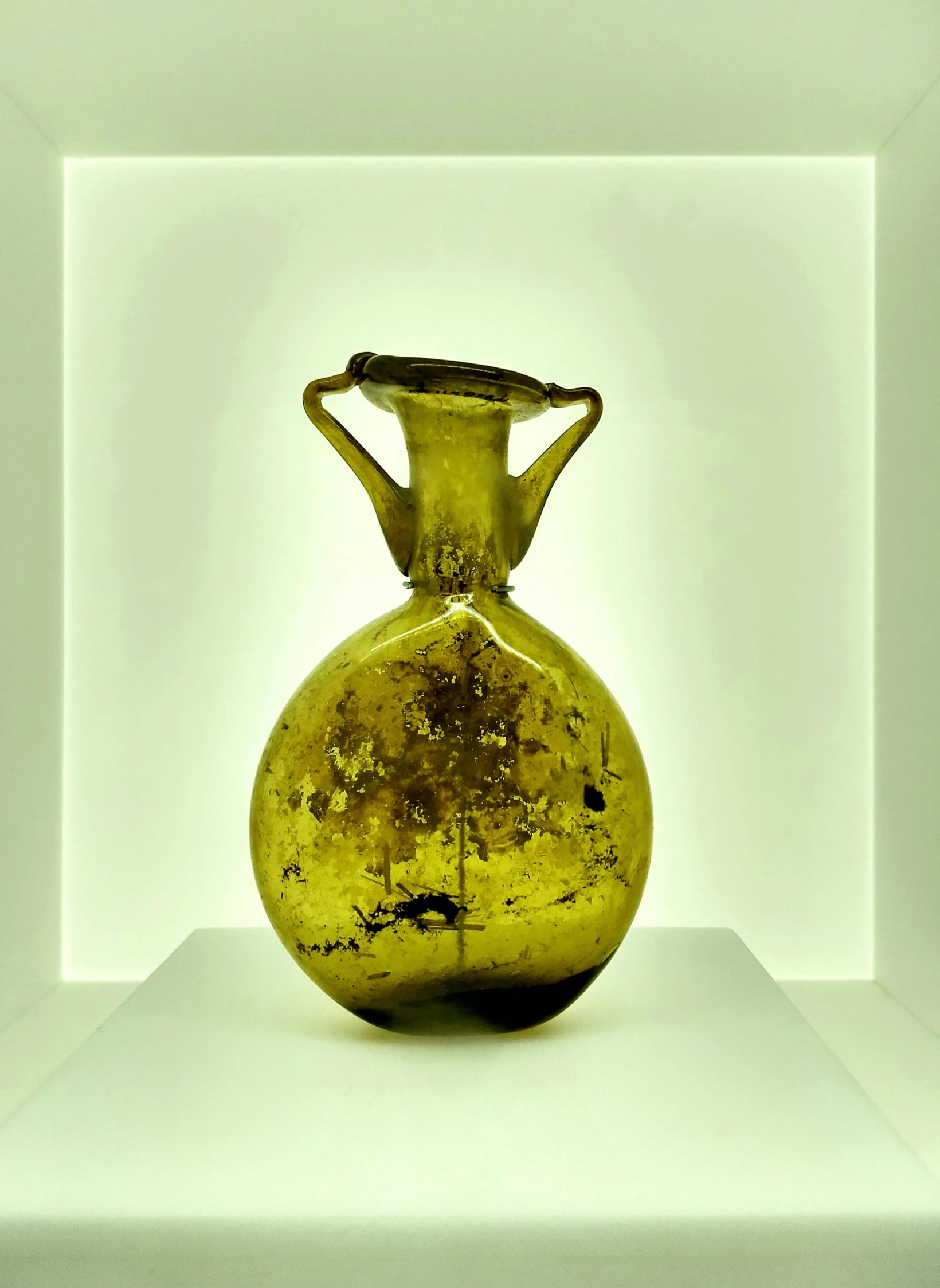 a yellow vase sitting on top of a white shelf, by Miroslava Sviridova, renaissance, glass antikythera, taken in 2 0 2 0, museum quality photo, full of greenish liquid