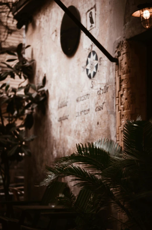 a building with a clock on the side of it, by Riad Beyrouti, trending on unsplash, graffiti, plants inside cave, sepia tones, lush oasis, dark warm light