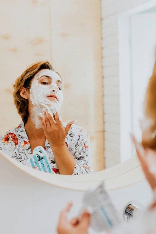 a woman shaving her face in front of a mirror, a picture, trending on pexels, covered in white flour, polka dot, white mask, pixelated