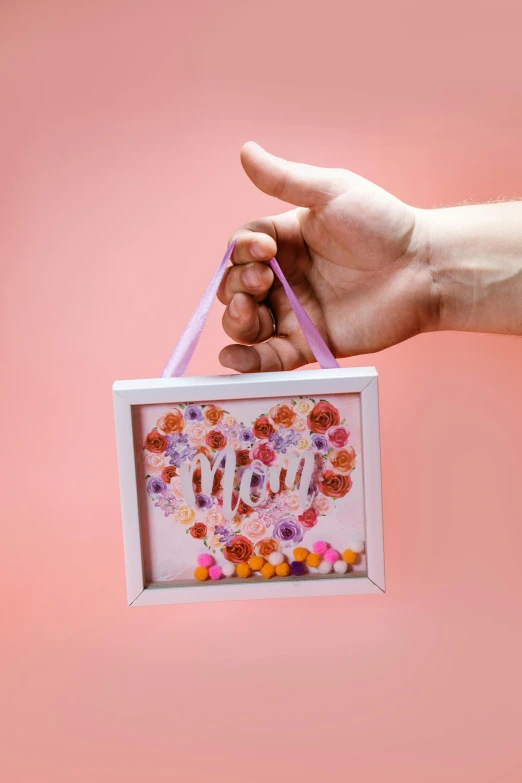 a close up of a person holding a sign, a picture, made of colorful dried flowers, your mom, 3 d print, mount