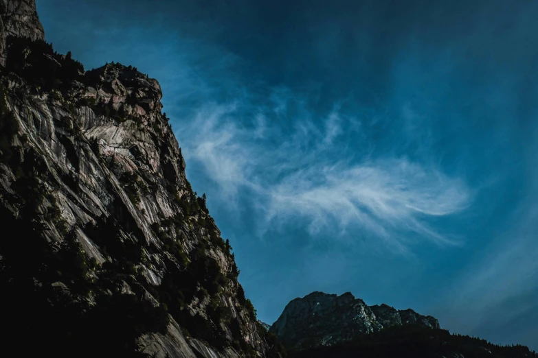 a person standing on top of a mountain under a cloudy sky, an album cover, by Sebastian Spreng, unsplash contest winner, extremely detailed rocky crag, new hampshire mountain, low angle 8k hd nature photo, 4 k hd wallpapear