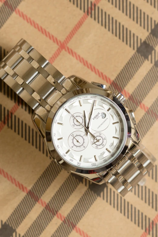 a close up of a watch on a table, a portrait, inspired by Edward Clark, unsplash, burberry, shiny silver, thumbnail, 8l