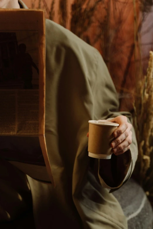 a man reading a newspaper while holding a cup of coffee, a picture, by Eglon van der Neer, trending on unsplash, renaissance, brown hooded cloak, avatar image, [ cinematic, wearing nanotech honeycomb robe