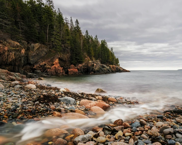 a rocky beach surrounded by trees on a cloudy day, inspired by Bascove, unsplash contest winner, boston, 4k image”, slow shutter speed, conde nast traveler photo