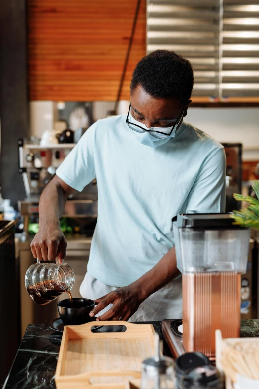 a man pouring something into a blender in a kitchen, pexels contest winner, renaissance, starbucks aprons and visors, iced latte, avatar image, mkbhd